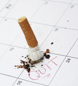 Cigarette butt put out on calendar that notes the smokers target quit date.